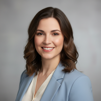 Woman wearing a light blue blazer against a gray background
