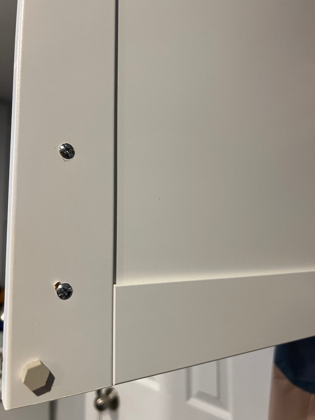 Cleaned cupboard surface with two screws and a hexagonal hole.