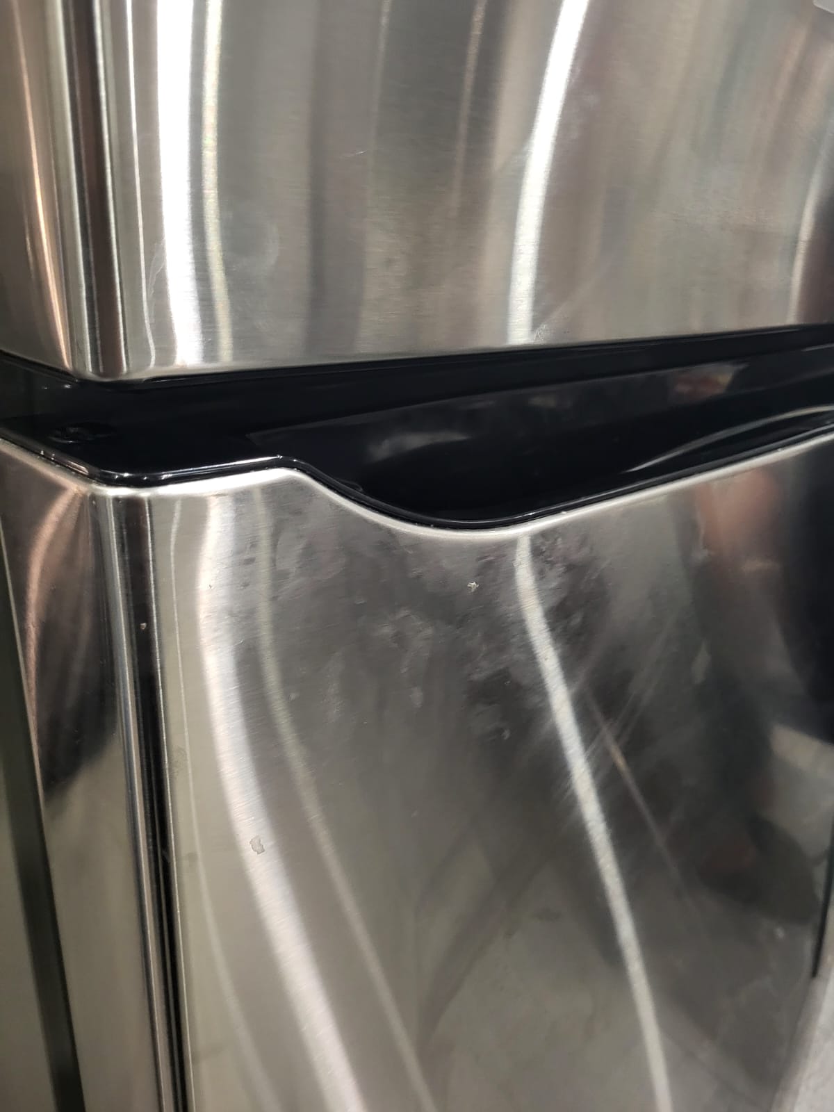 Close-up of a metallic fridge surface with with hand marks or dirt